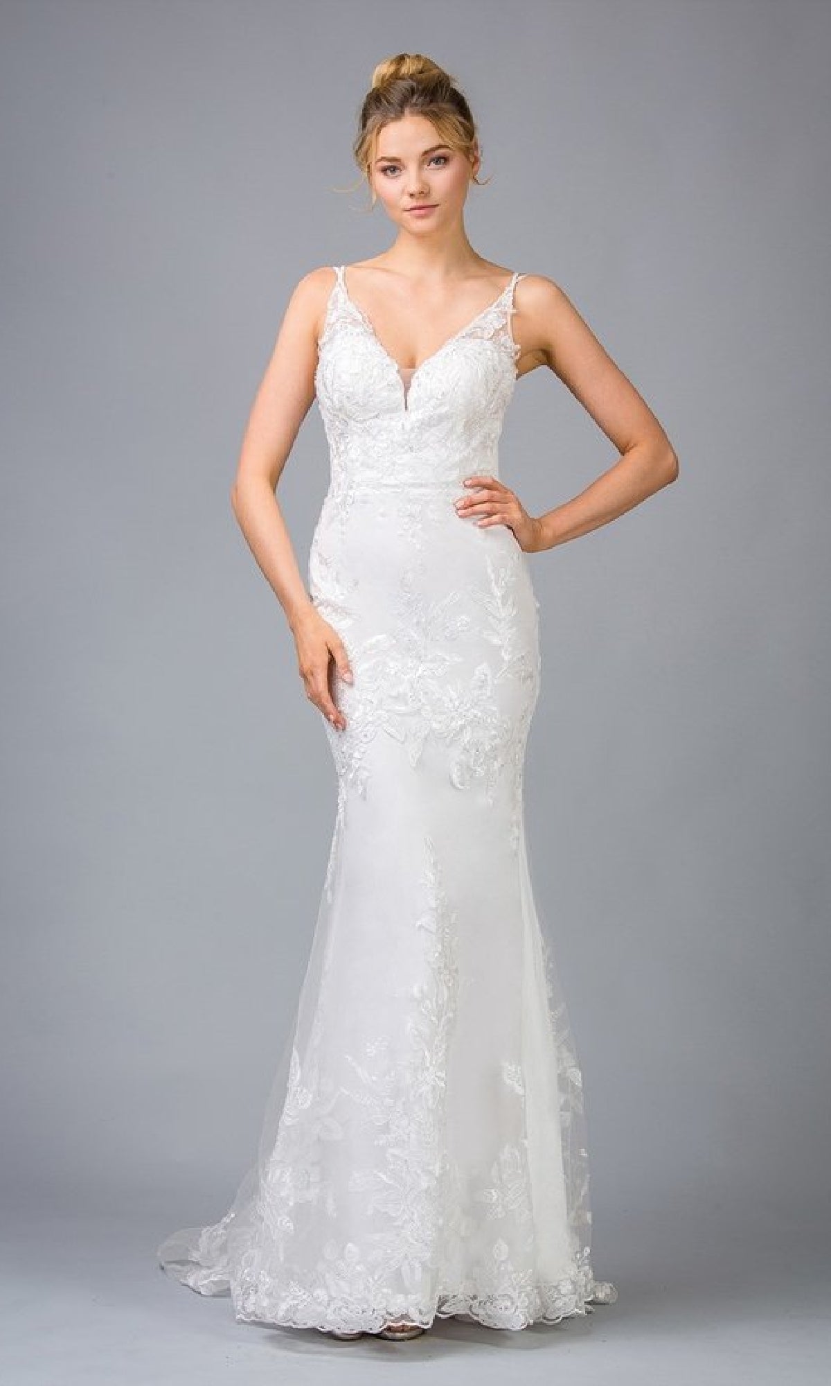 A woman poses against a gray background wearing the Eureka 9130 Long Embroidered-Lace Prom Dress, a white, sleeveless formal gown with thin straps and a fitted, floor-length silhouette.